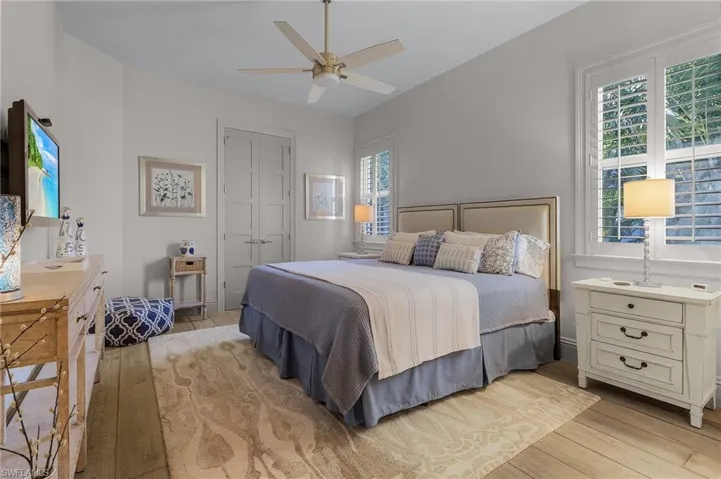 Bedroom with light wood-type flooring, a closet, and ceiling fan