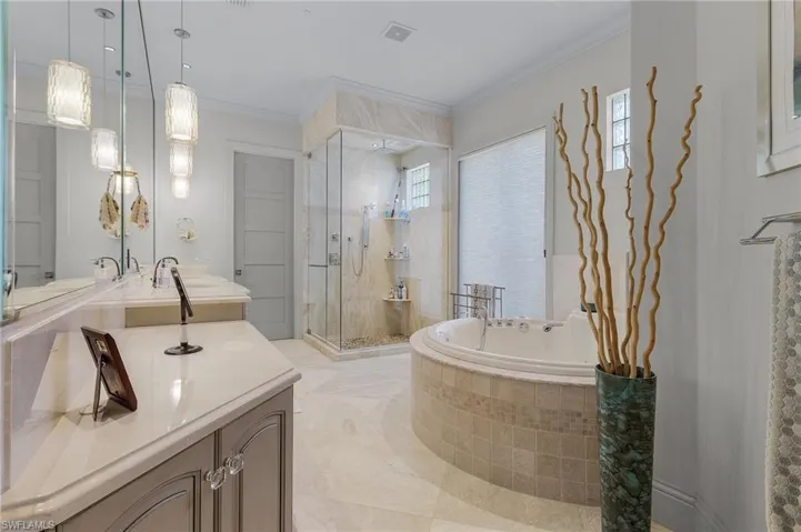 Bathroom with vanity, crown molding, and separate shower and tub