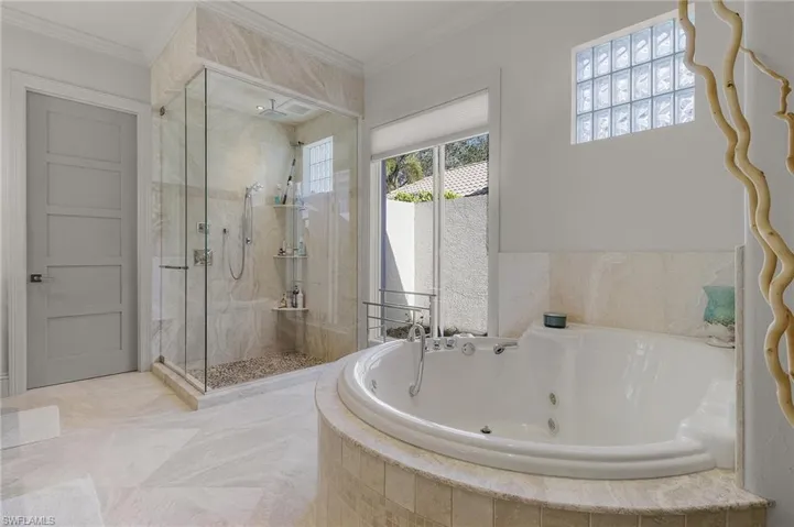 Bathroom featuring crown molding and separate shower and tub