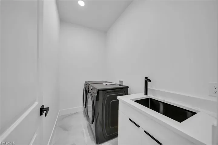 Laundry room with recessed lighting and separate washer and dryer