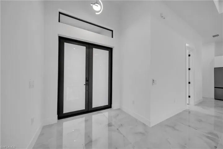 Foyer with french doors and light marble finish floors