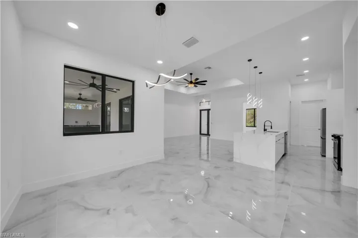 Spare room featuring a ceiling fan, recessed lighting, and light marble finish floors