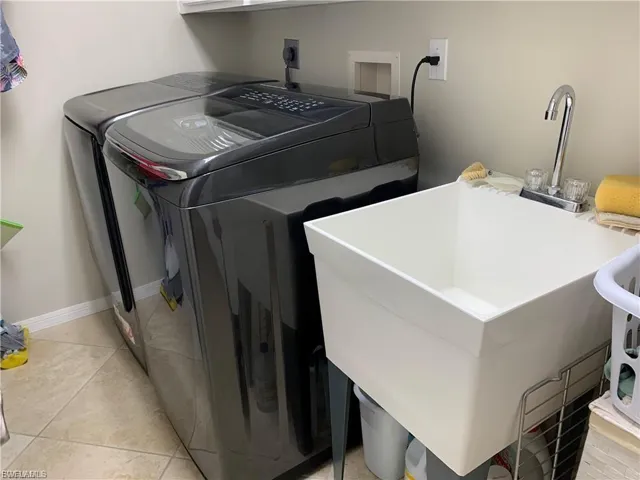 Washroom featuring light tile patterned floors and washer and dryer