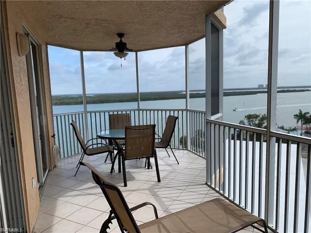 Sunroom featuring a wall of windows, a water view, and tile patterned floors