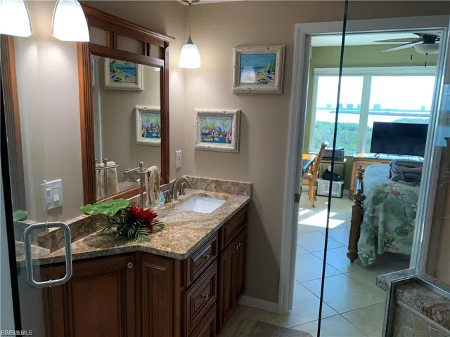 Bathroom featuring vanity, ceiling fan, and light tile patterned floors