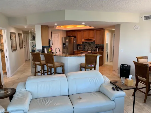 Living room featuring light tile patterned flooring, recessed lighting, and a textured ceiling