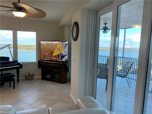 Living room with a ceiling fan and light tile patterned flooring