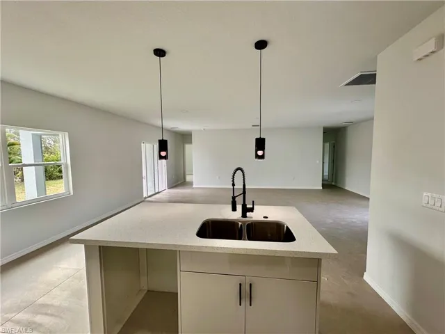 Kitchen with decorative light fixtures, open floor plan