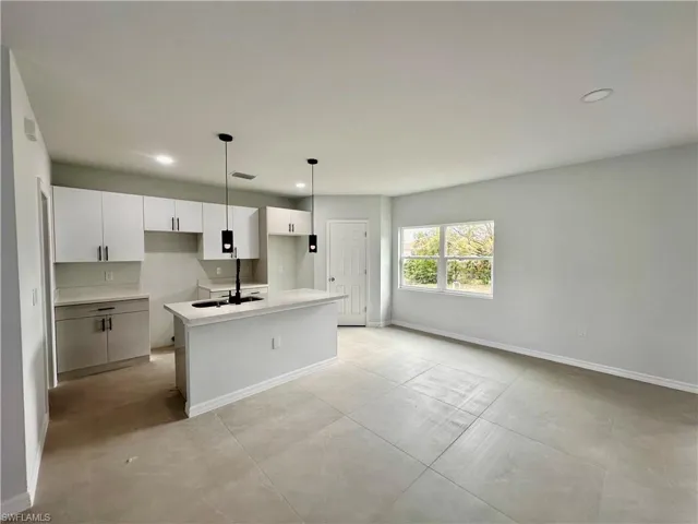 Kitchen with white cabinets a center island and recessed lighting