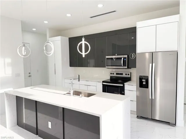 Kitchen with appliances with stainless steel finishes, modern cabinets, light marble finish floors, hanging light fixtures, and recessed lighting
