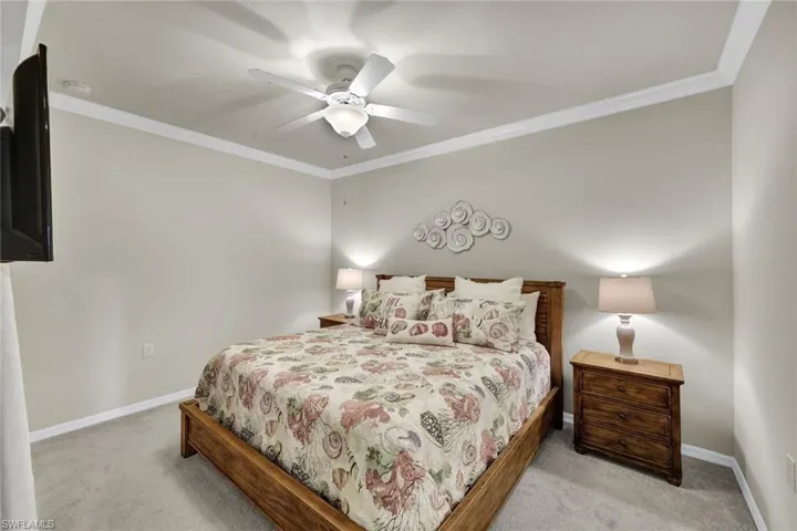 Bedroom featuring crown molding, ceiling fan, and light colored carpet