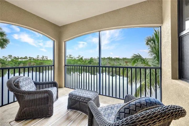 Sunroom featuring a water view and view of scattered trees