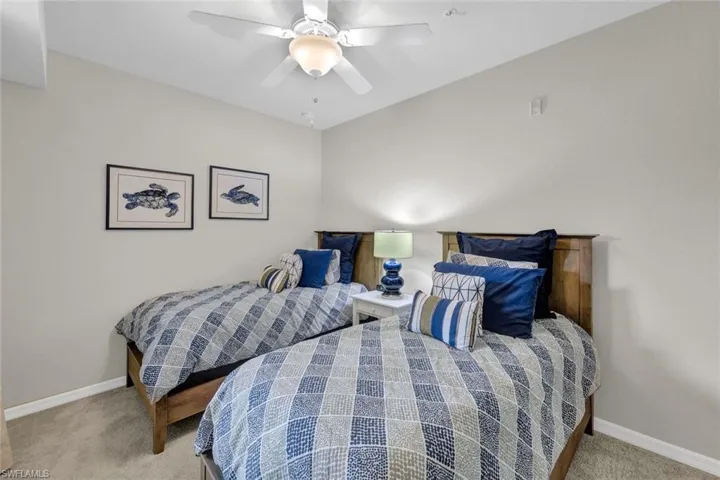 Bedroom with ceiling fan and light colored carpet