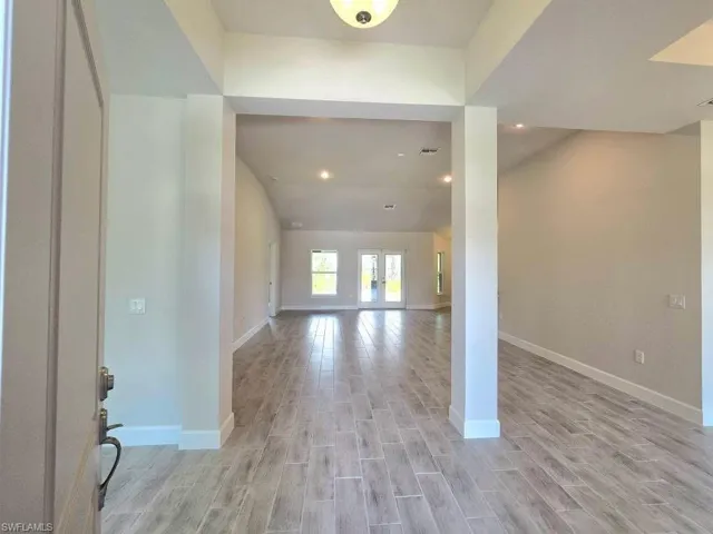 Foyer featuring light plank tile finished floors, baseboards, and recessed lighting