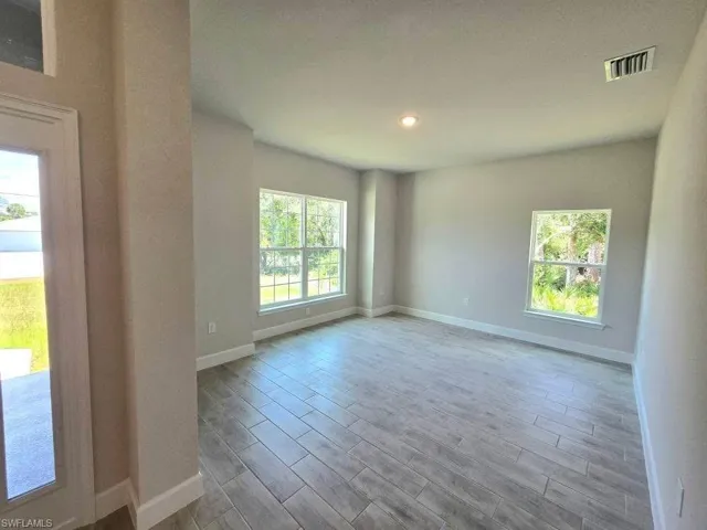 Living Room featuring baseboards, wood tiled floors, and recessed lighting