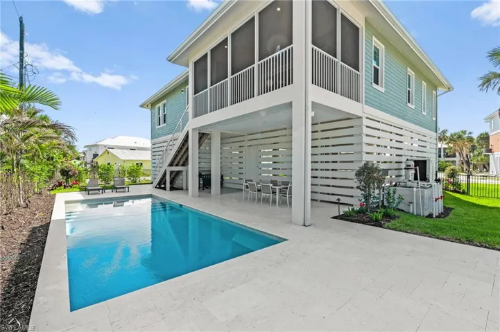 LET'S GO SWIMMING -Rear view of property with fence, a patio, a fenced in pool, a sunroom, and stairs. virtually edited photo