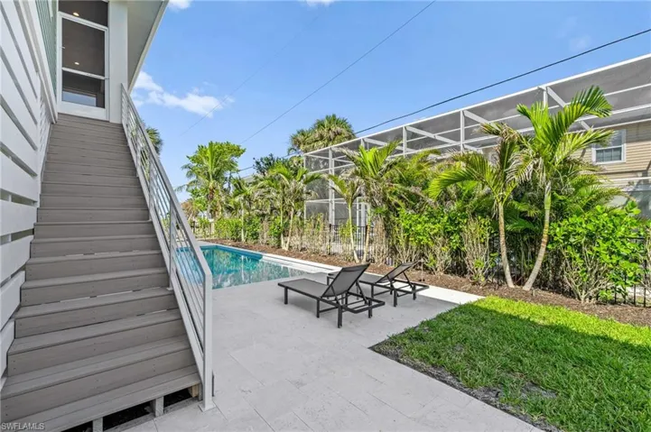 Outdoor pool featuring a patio area and stairs. virtually edited photo