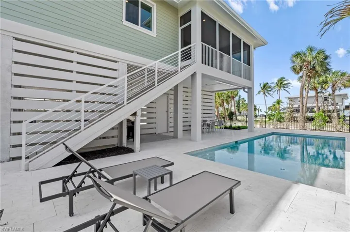 LAZY DAYS by the POOL - View of swimming pool with a patio area, fence, a fenced in pool, a sunroom, and stairs. virtually edited photo