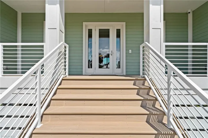 Doorway to property featuring a porch. virtually edited photo