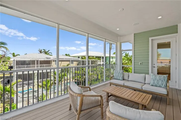 Screened in balcony with outdoor lounge area. virtually edited photo