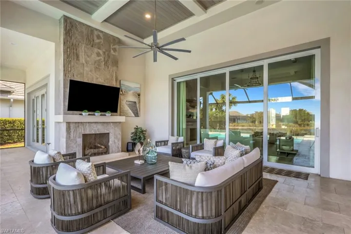 View of patio with an outdoor living space with a fireplace, a ceiling fan, and french doors