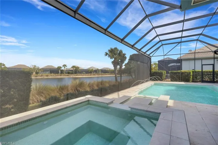 Outdoor pool featuring an in-ground hot tub, a sunroom, a patio, a lanai, and a water view