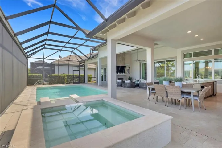Relaxing pool / spa featuring a patio, outdoor dining area, a sunroom, and a lanai