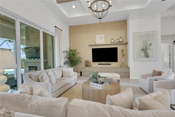 Living room with a chandelier, coffered ceiling, and a tile fireplace
