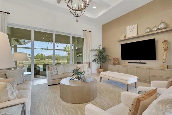 Living area featuring suspended lighting and a high ceiling