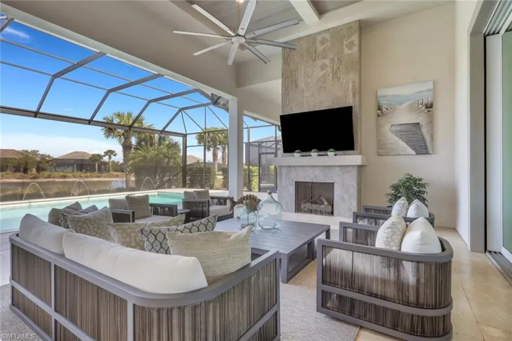 View of patio / terrace featuring a lanai, an outdoor living space with a fireplace, a sunroom, and an outdoor pool