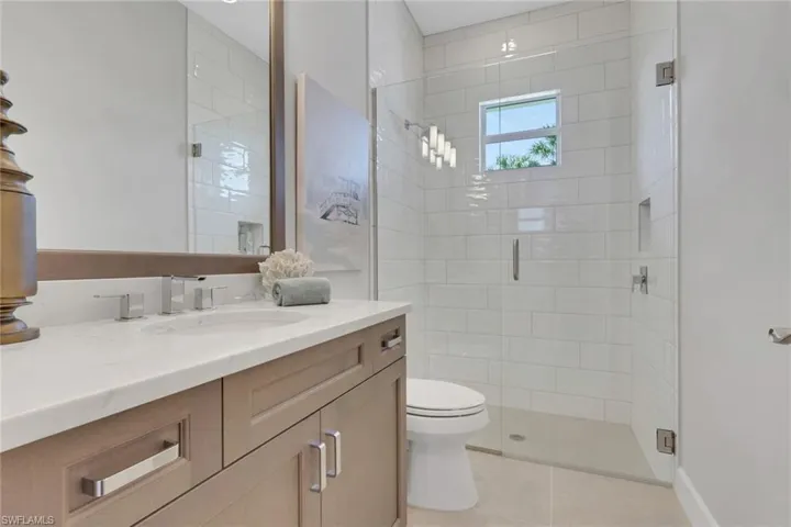 Bathroom featuring vanity, a stall shower, and light tile patterned flooring