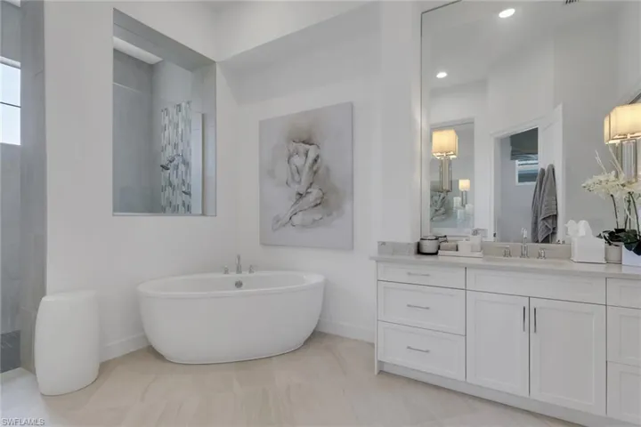 Bathroom with vanity, walk in shower, and a freestanding tub