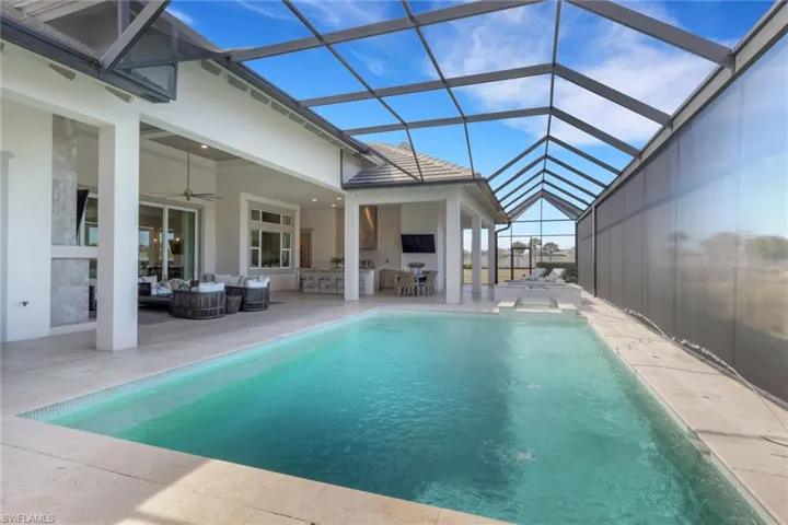 Outdoor pool featuring outdoor furniture, a patio area, a sunroom, and a lanai