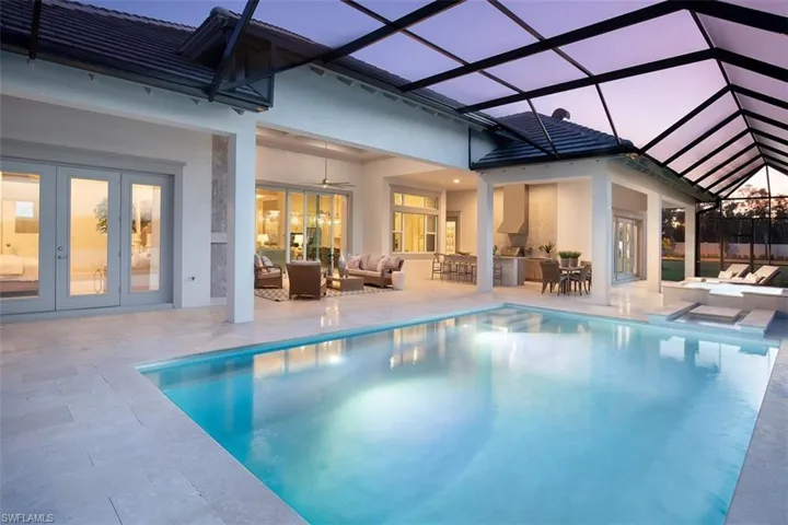 Outdoor pool featuring a lanai, a sunroom, french doors, and an outdoor lounge area with bar