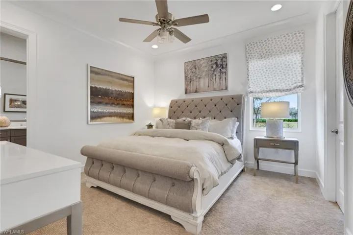 Carpeted bedroom with a ceiling fan and recessed lighting