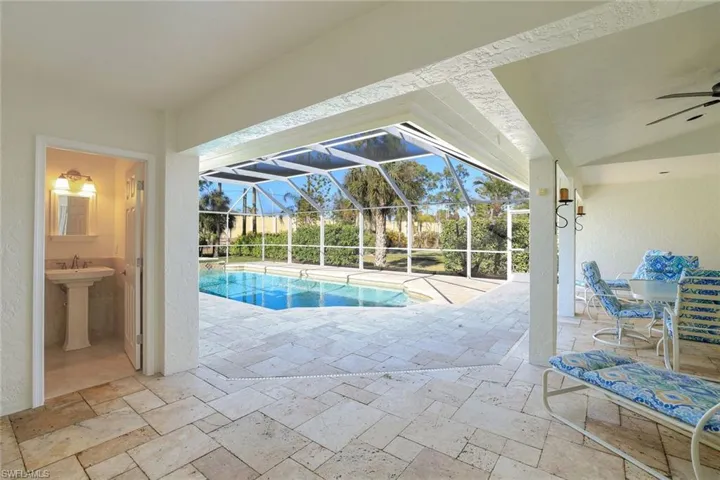 Outdoor pool with a patio, a sunroom, glass enclosure, and outdoor dining space