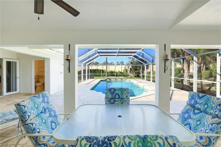 Swimming pool featuring outdoor dining area, a sunroom, a patio, and a lanai
