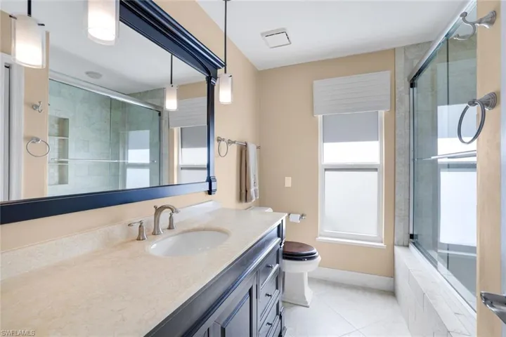 Bathroom featuring vanity, light tile patterned floors, and tiled shower / bath