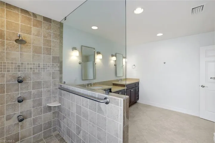 Bathroom featuring two sinks, walk in shower, and recessed lighting