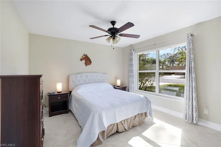 Bedroom with a ceiling fan and light tile patterned flooring