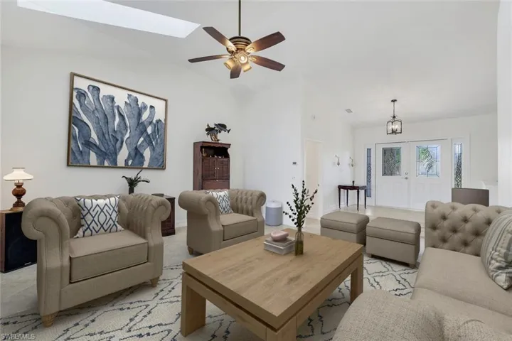 Virtually Staged Living area featuring lofted ceiling, ceiling fan, a skylight, and suspended lighting