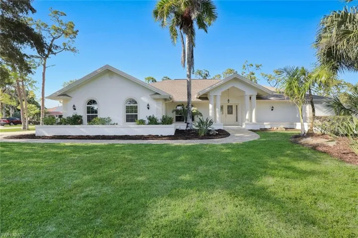 Single story home featuring concrete block with stucco and a front lawn