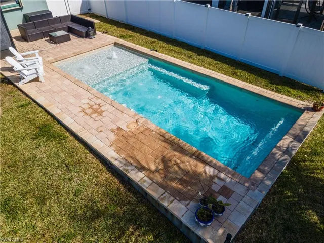 View of swimming pool with an outdoor lounge area, a fenced backyard, and patio surround