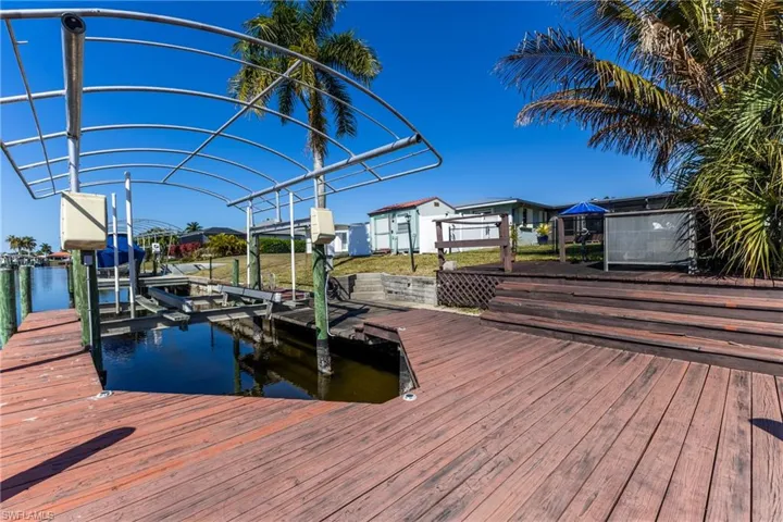 Dock area featuring boat lift, a water view, and a residential view