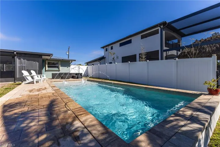 View of pool with a fenced backyard, patio surround, and a sunroom