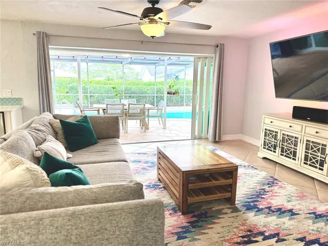 Tiled living room with ceiling fan and a textured ceiling