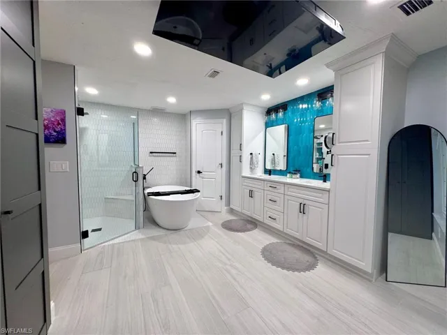 Bathroom with vanity, independent shower and bath, and hardwood / wood-style flooring