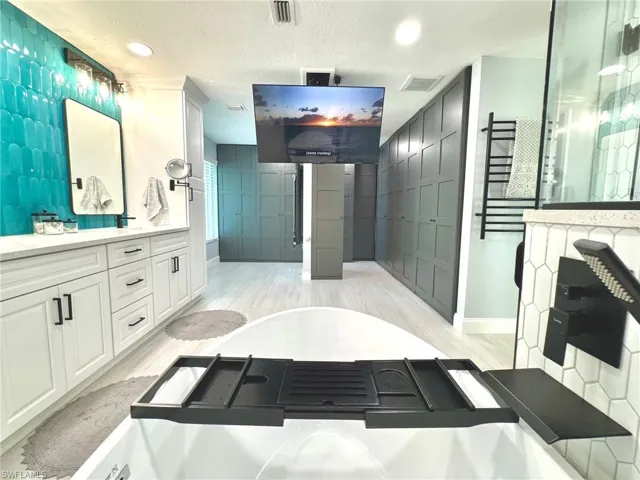 Bathroom featuring vanity, wood-type flooring, and a textured ceiling