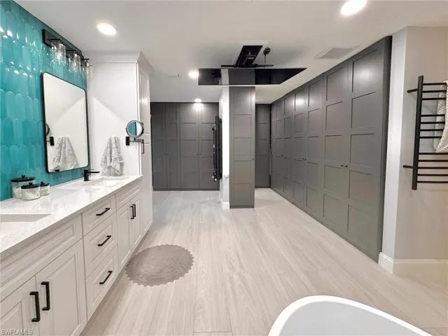 Bathroom featuring a washtub, vanity, and hardwood / wood-style flooring