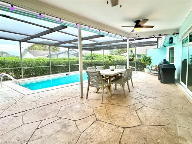 View of pool with a patio, ceiling fan, and a lanai